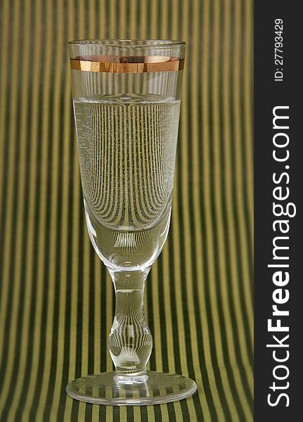 Vintage vodka glass on striped background.