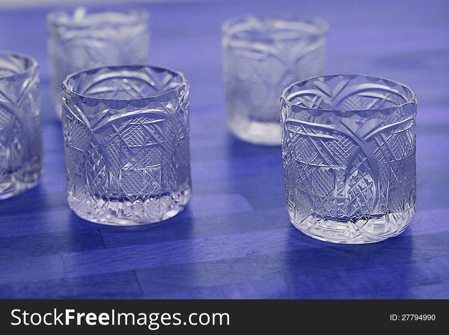 Vintage crystal vodka glasses on table.