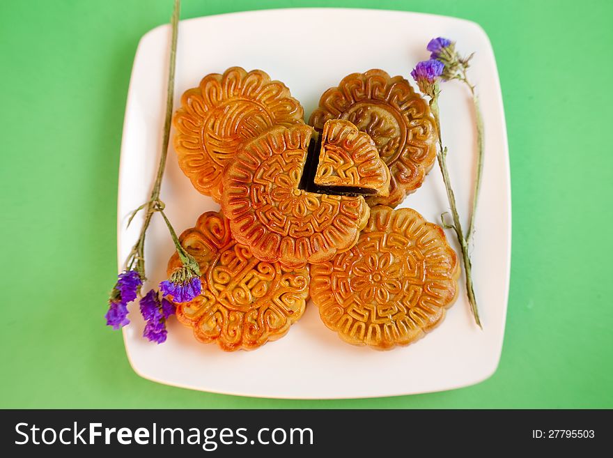 Chinese traditional moon cake in plate with flower. Chinese traditional moon cake in plate with flower