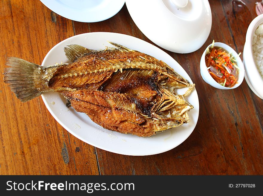 Fried fish on a plate with a delicious sauce. Fast food. Fried fish on a plate with a delicious sauce. Fast food.