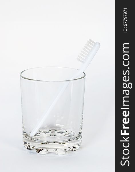 Toothbrush in a glass beaker on a white background. Toothbrush in a glass beaker on a white background