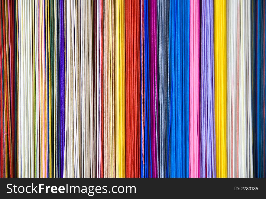 Colourful threads that form a diverse coloured background.
