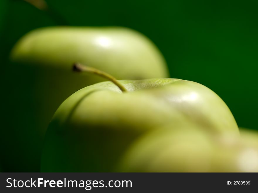 Three green apple on green background.