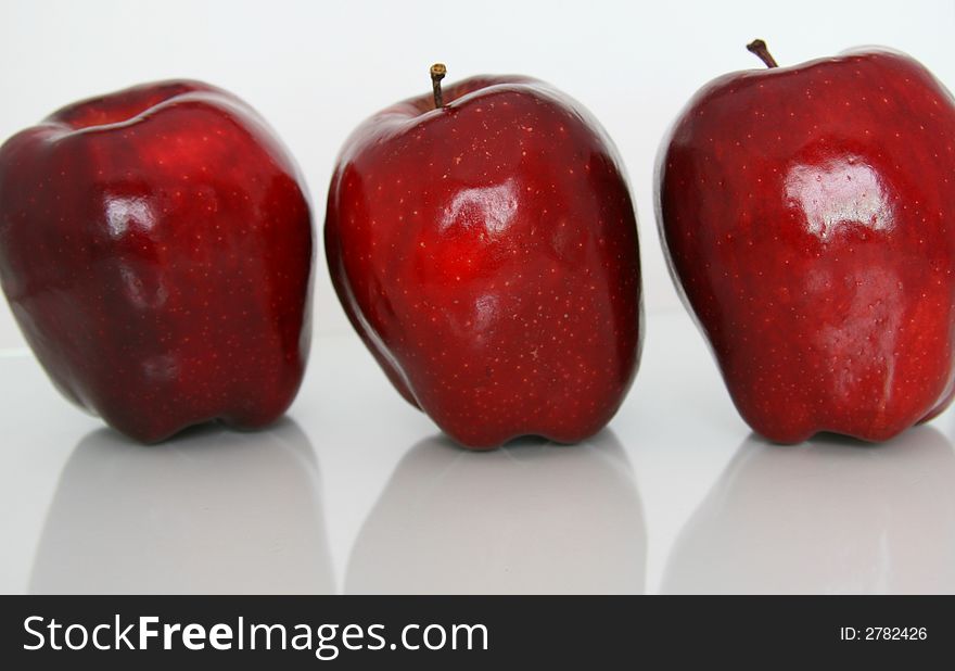 Three Red Apples against white backgroung with reflection