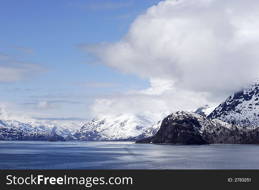 The view of snow-covered mountains and clouds in Glacier Bay national park, Alaska. The view of snow-covered mountains and clouds in Glacier Bay national park, Alaska.