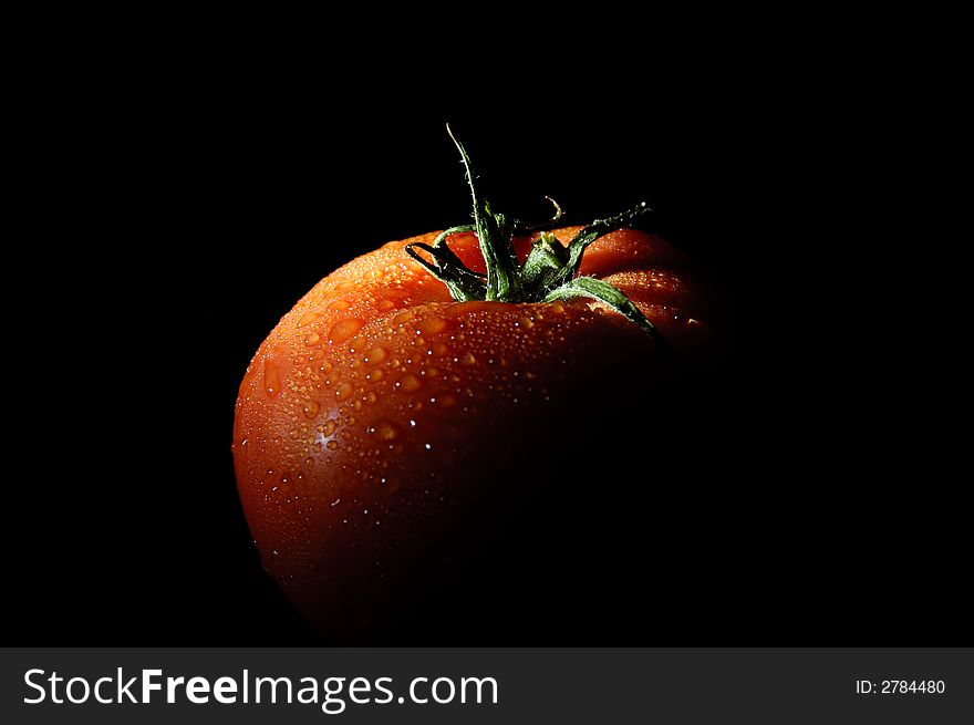 Image of a refreshing tomato on black background.