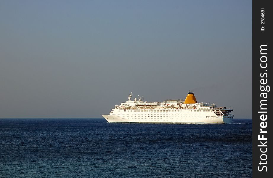 Big Cruise-ship in deep blue water, sunset warm light. Big Cruise-ship in deep blue water, sunset warm light