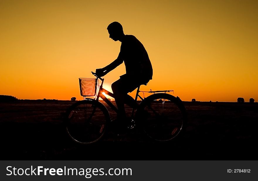 Man and  bike  silhouette in orange sunrise. Man and  bike  silhouette in orange sunrise