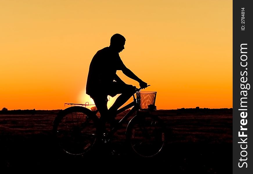 Man and  bike  silhouette in orange sunrise. Man and  bike  silhouette in orange sunrise