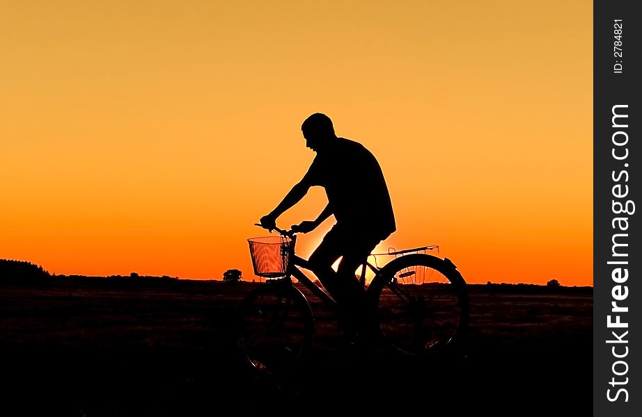 Man and bike silhouette in orange sunrise. Man and bike silhouette in orange sunrise