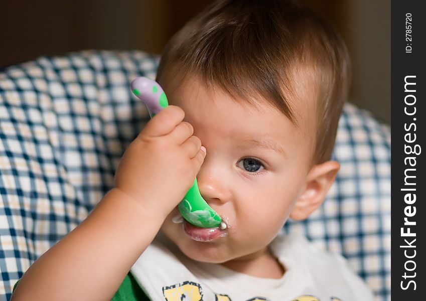 Little kid feeding by himself with a spoon. Little kid feeding by himself with a spoon