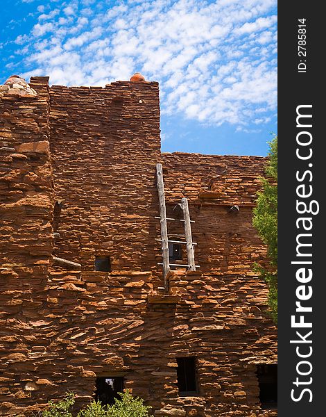 Adobe Red Rock house and latter with wispy white clounds and blue sky