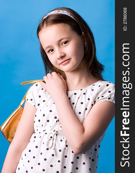 The girl of ten years poses with a gold handbag in a hand. The girl of ten years poses with a gold handbag in a hand