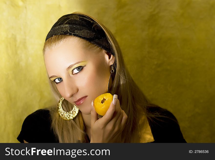 Attractive girl with apricot on yellow background
