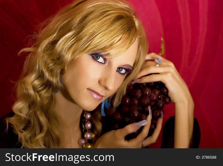 Young beautiful  blond girl with grapes