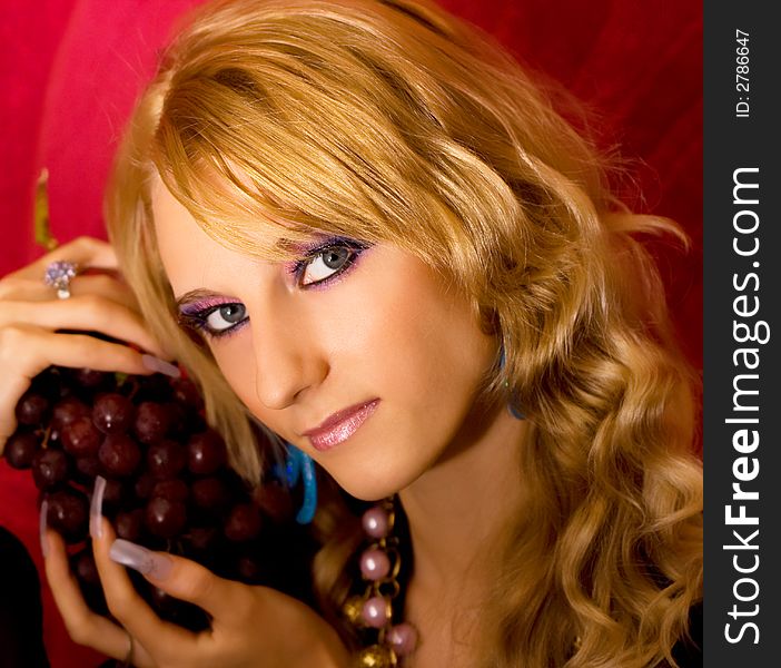 Young beautiful blond girl with grapes bunch