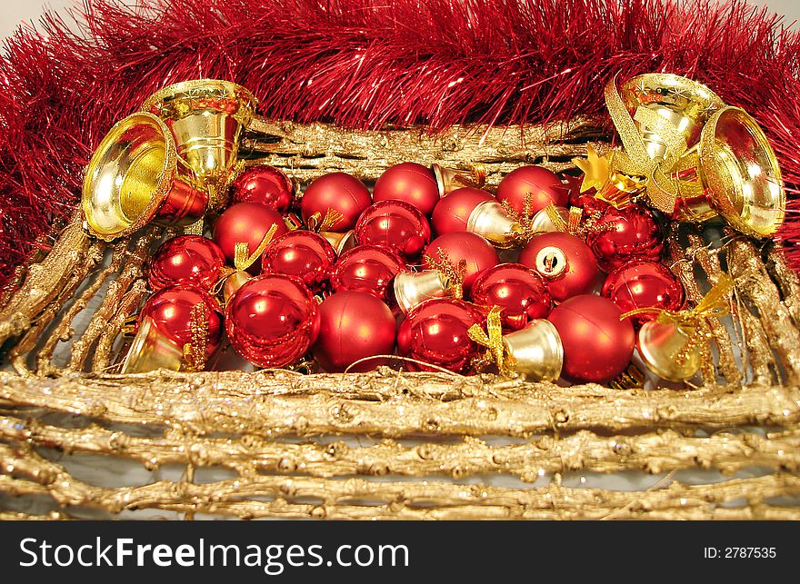 Red Christmas balls and handbells on golden frame with garland