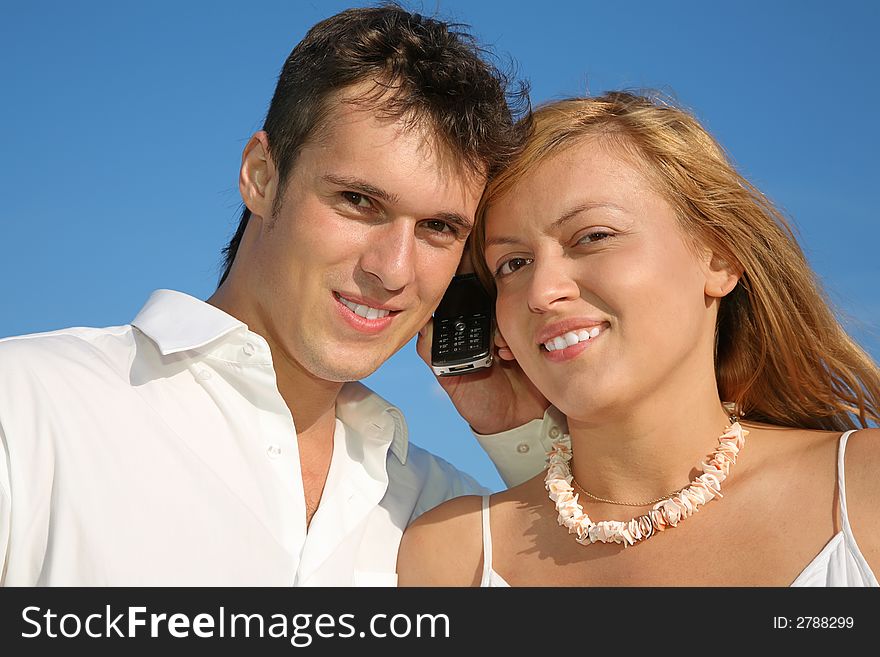 Man, woman and cell phone with blue sky