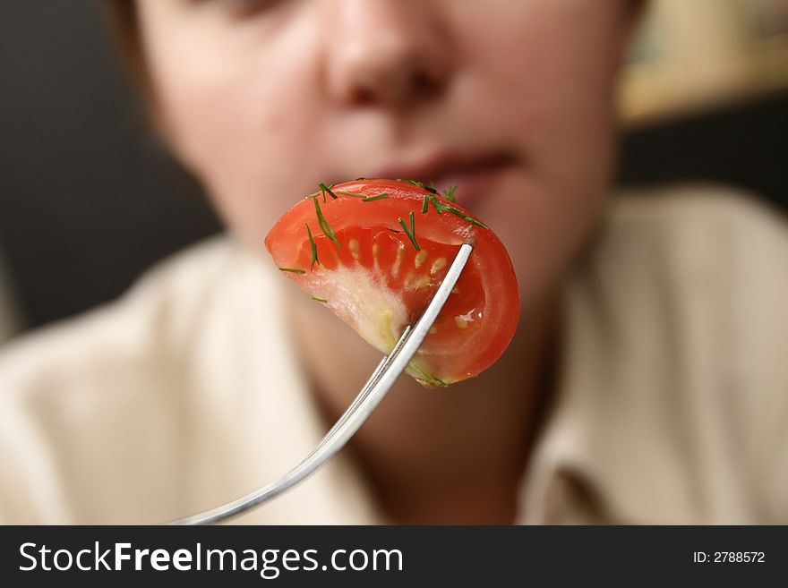 Titbit of tomato with dill on fork
