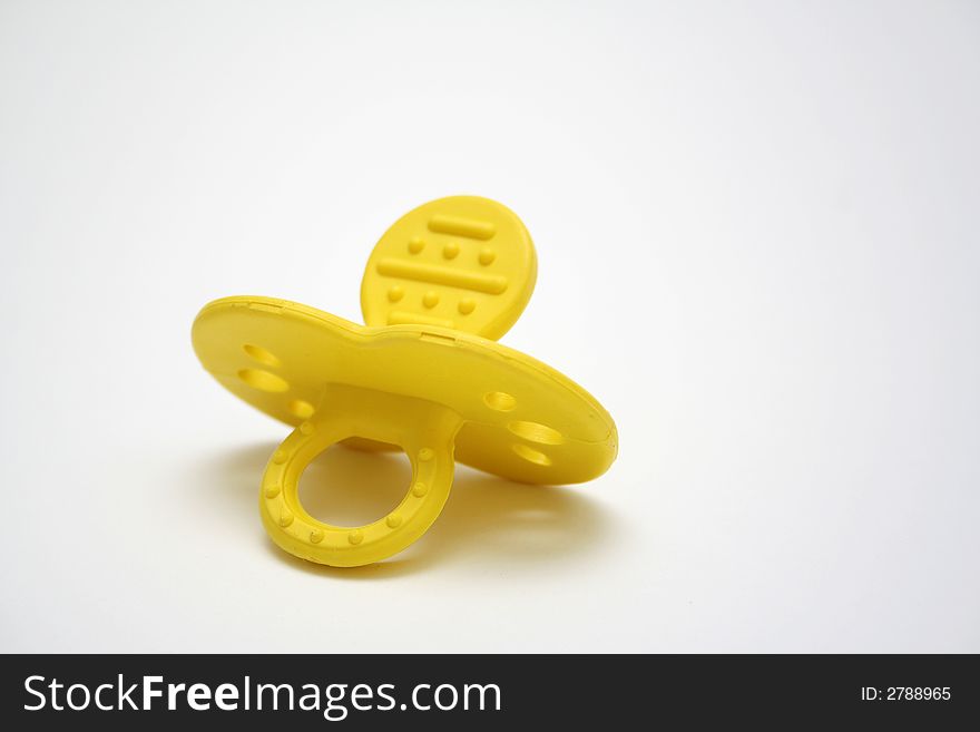 Yellow baby pacifier on white background