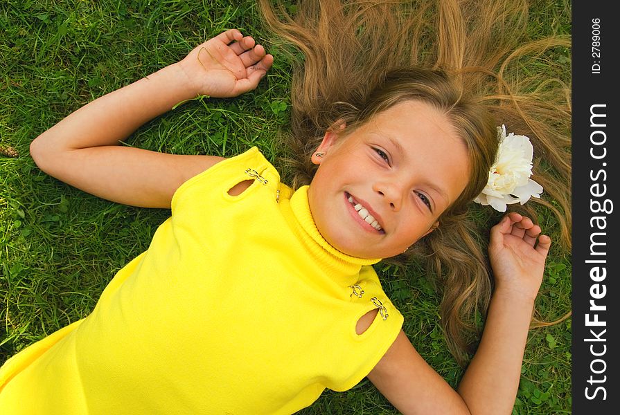 Little girl lying on a green grass