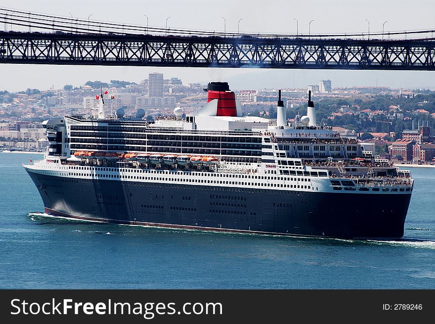 Luxury cruise ship, sailling away from Lisbon, passing under the Lisbon's bridge. Luxury cruise ship, sailling away from Lisbon, passing under the Lisbon's bridge