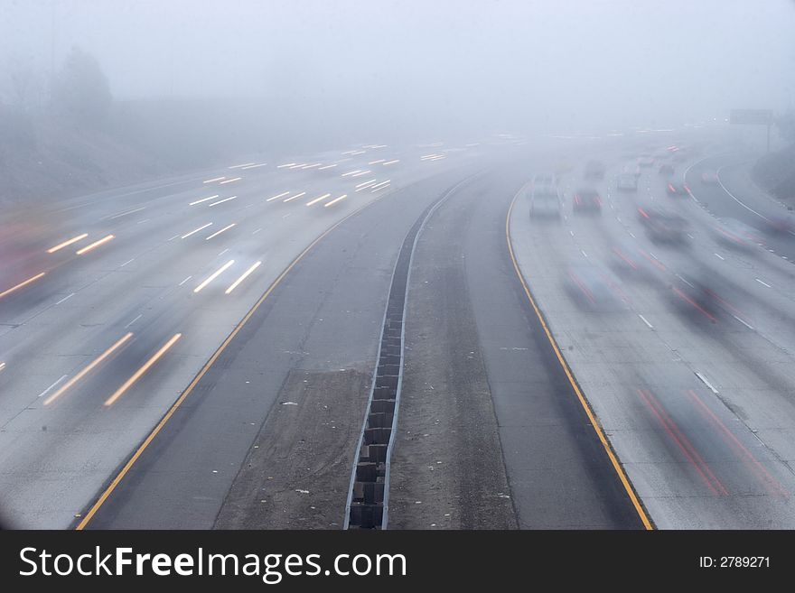 Cars speed under an over pass on a foggy morning. Cars speed under an over pass on a foggy morning