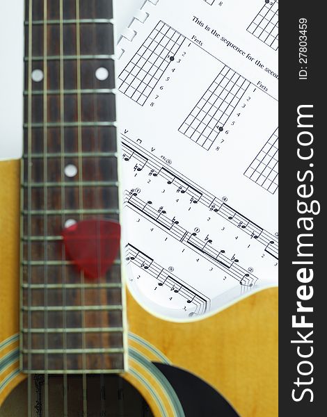 Acoustic Guitar on music note sheet ,focus at music note sheet.