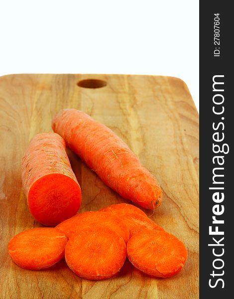 Carrots whole and sliced lie on wooden board. Carrots whole and sliced lie on wooden board