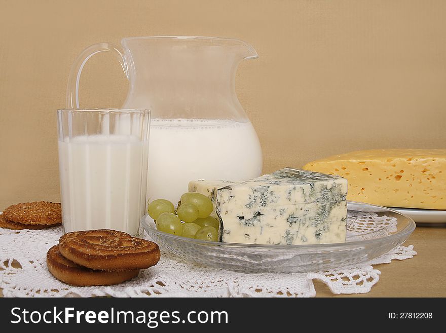 Jug and glass full of milk, cheese, grape and some cookies. Jug and glass full of milk, cheese, grape and some cookies.
