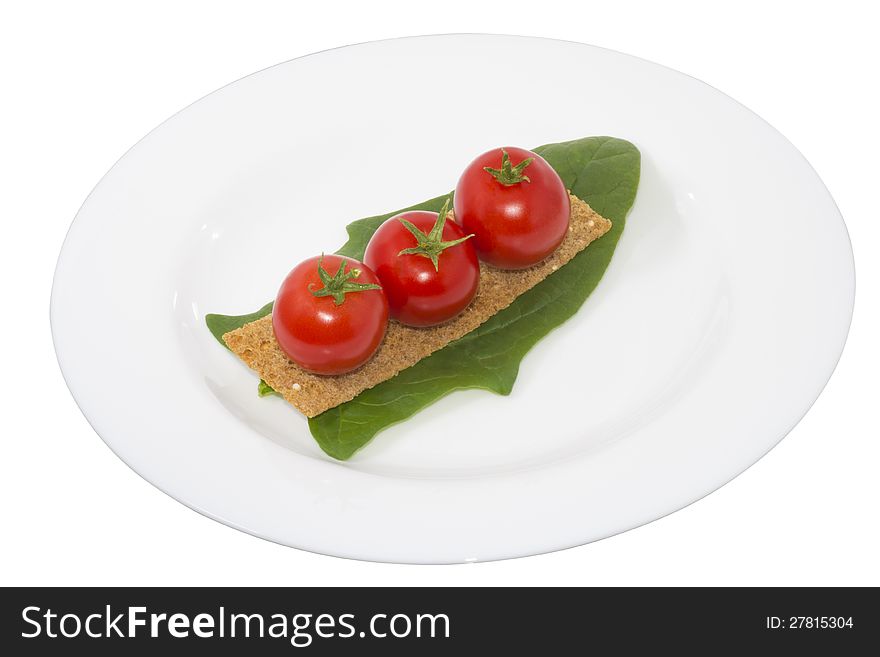 Tomato on crouton and a leaf spinach in a plate