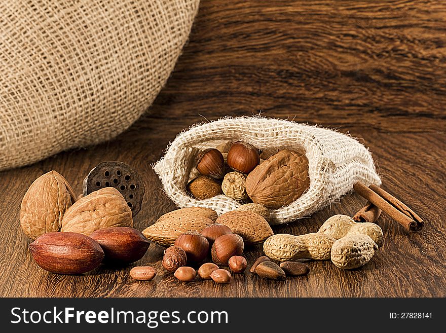 Nuts in burlap sack on wooden table. Nuts in burlap sack on wooden table