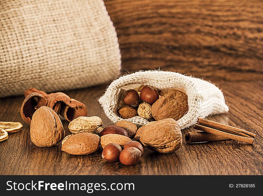 Nuts in burlap sack on wooden table. Nuts in burlap sack on wooden table
