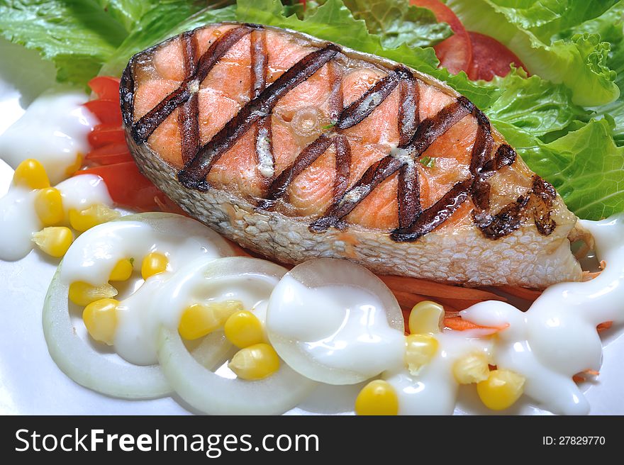 Grilled salmon steak with salad