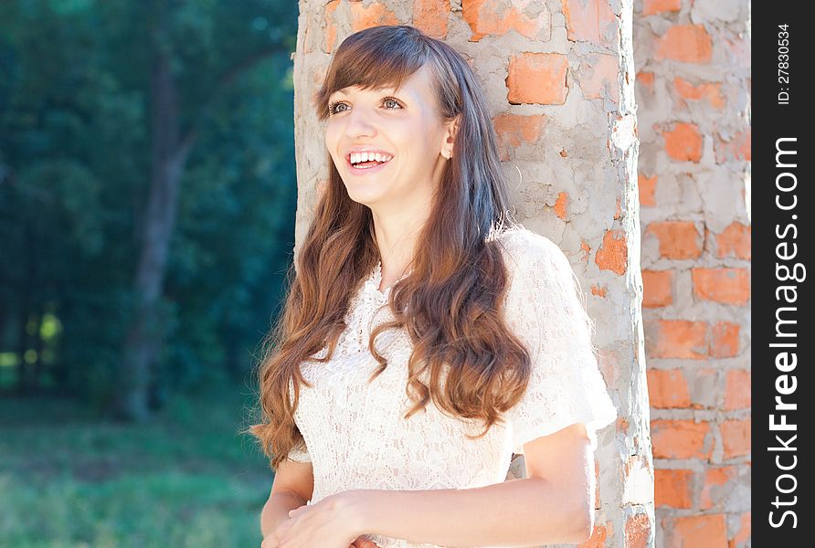 Girl near a brick columns rejoices her new home