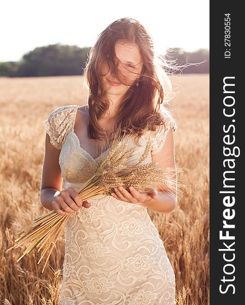 Girl with freckles in a wheat field