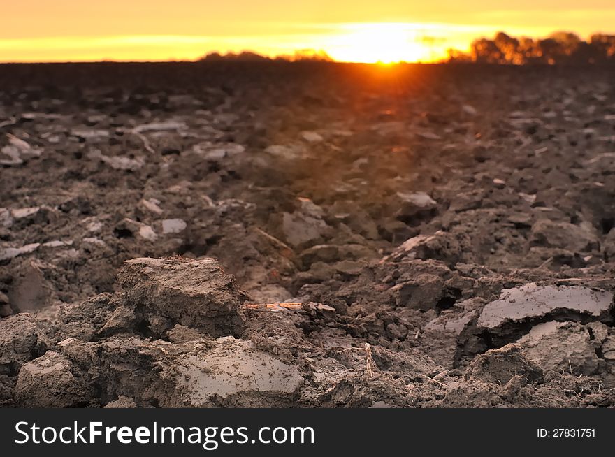 Field of freshly turned topsoil forming clods of earth at twilight. Field of freshly turned topsoil forming clods of earth at twilight