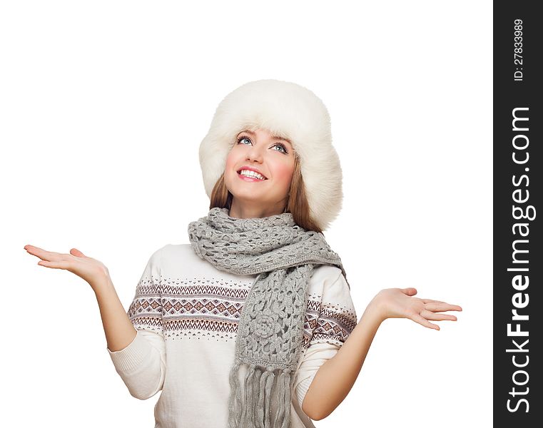 Young blond woman in scarf and fur hat lifts hands, looks up. isolated on white. Young blond woman in scarf and fur hat lifts hands, looks up. isolated on white