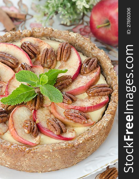 Cheesecake with apples and caramelized pecans closeup
