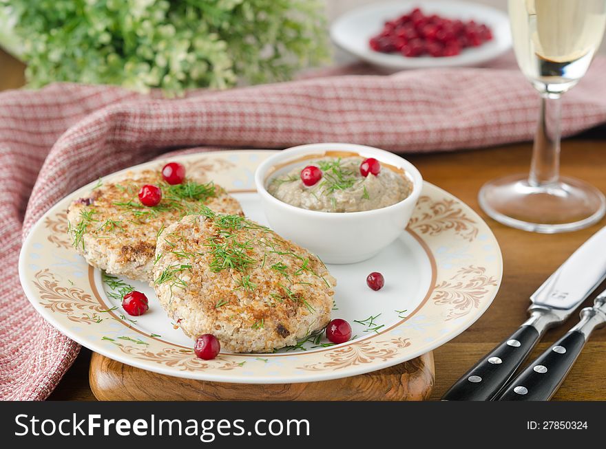 Chicken cutlets with cowberry and mushroom sauce to decorated table