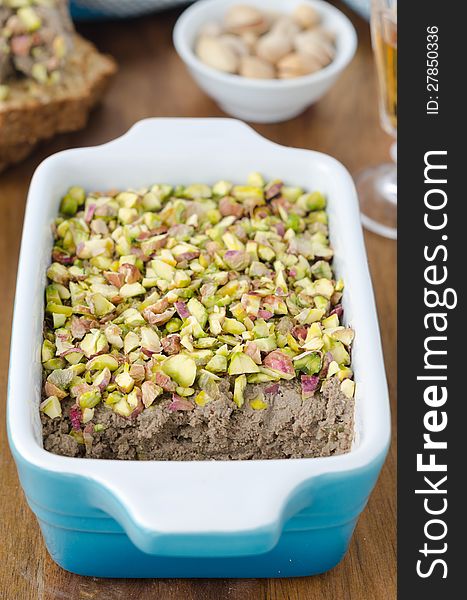 Chicken liver pate with pistachios closeup on a wooden table. Chicken liver pate with pistachios closeup on a wooden table