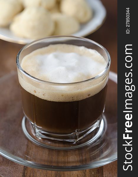 Glass cup of coffee with froth with shortbread, selective focus