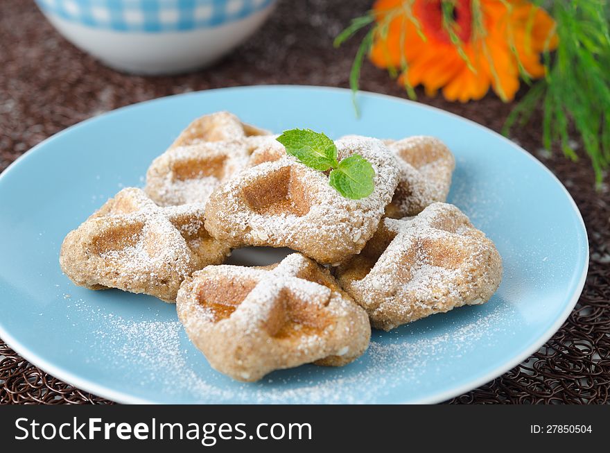 Waffles sprinkled with powdered sugar and black tea. Waffles sprinkled with powdered sugar and black tea