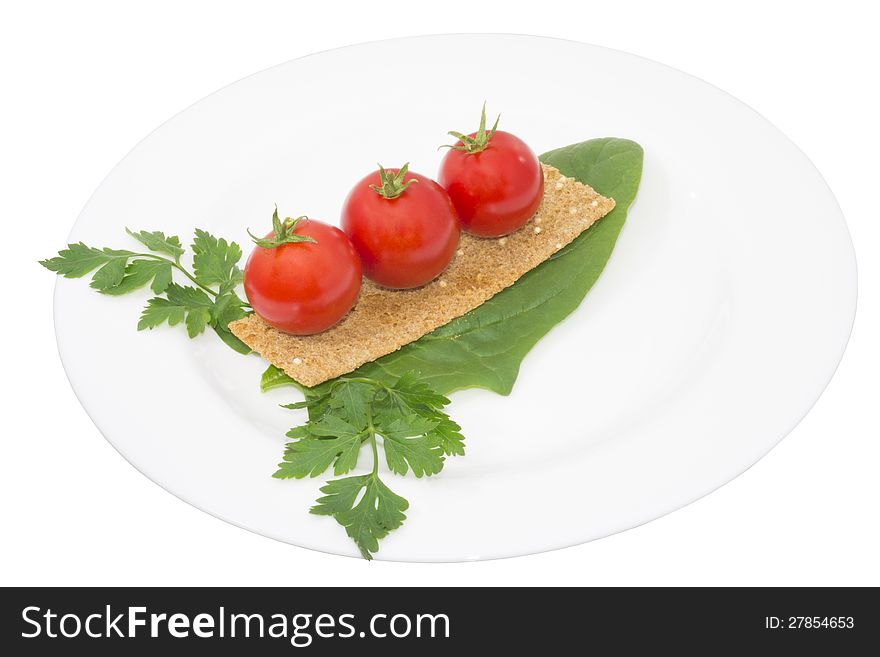 Tomato, snack and greens in a plate, isolated
