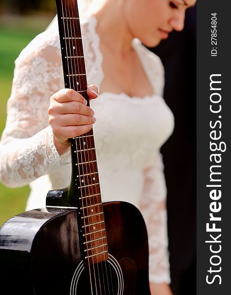 Bride in a white dress holding a hand guitar. Bride in a white dress holding a hand guitar