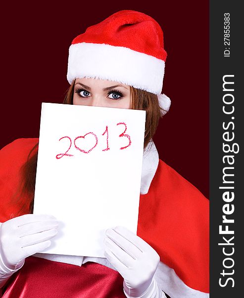 Girl in Santa's hat holding a sheet of paper with the inscription 2013. Girl in Santa's hat holding a sheet of paper with the inscription 2013