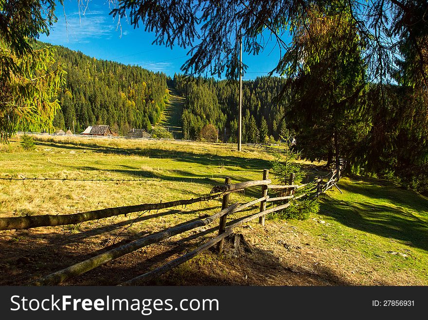 Beautiful rural landscape, which depicts a long wooden fence along the meadows in the Carpathian Mountains. Beautiful rural landscape, which depicts a long wooden fence along the meadows in the Carpathian Mountains