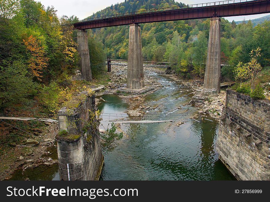 Old Ruined Railroad Bridge Crossing The River