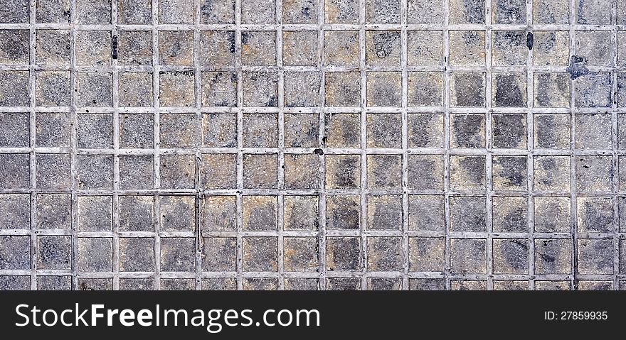 A section of squarish rough marble tiles, that are dirtied by use. A section of squarish rough marble tiles, that are dirtied by use