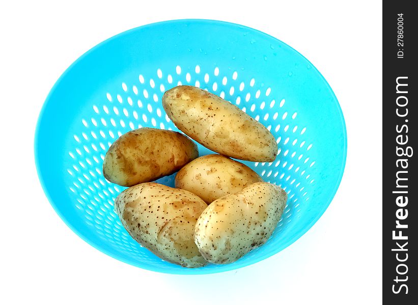 Potatoes that are cleaned to dry in a blue plastic strainer. Potatoes that are cleaned to dry in a blue plastic strainer